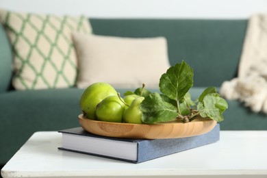 Photo of Fresh green apples on white wooden table in living room, space for text