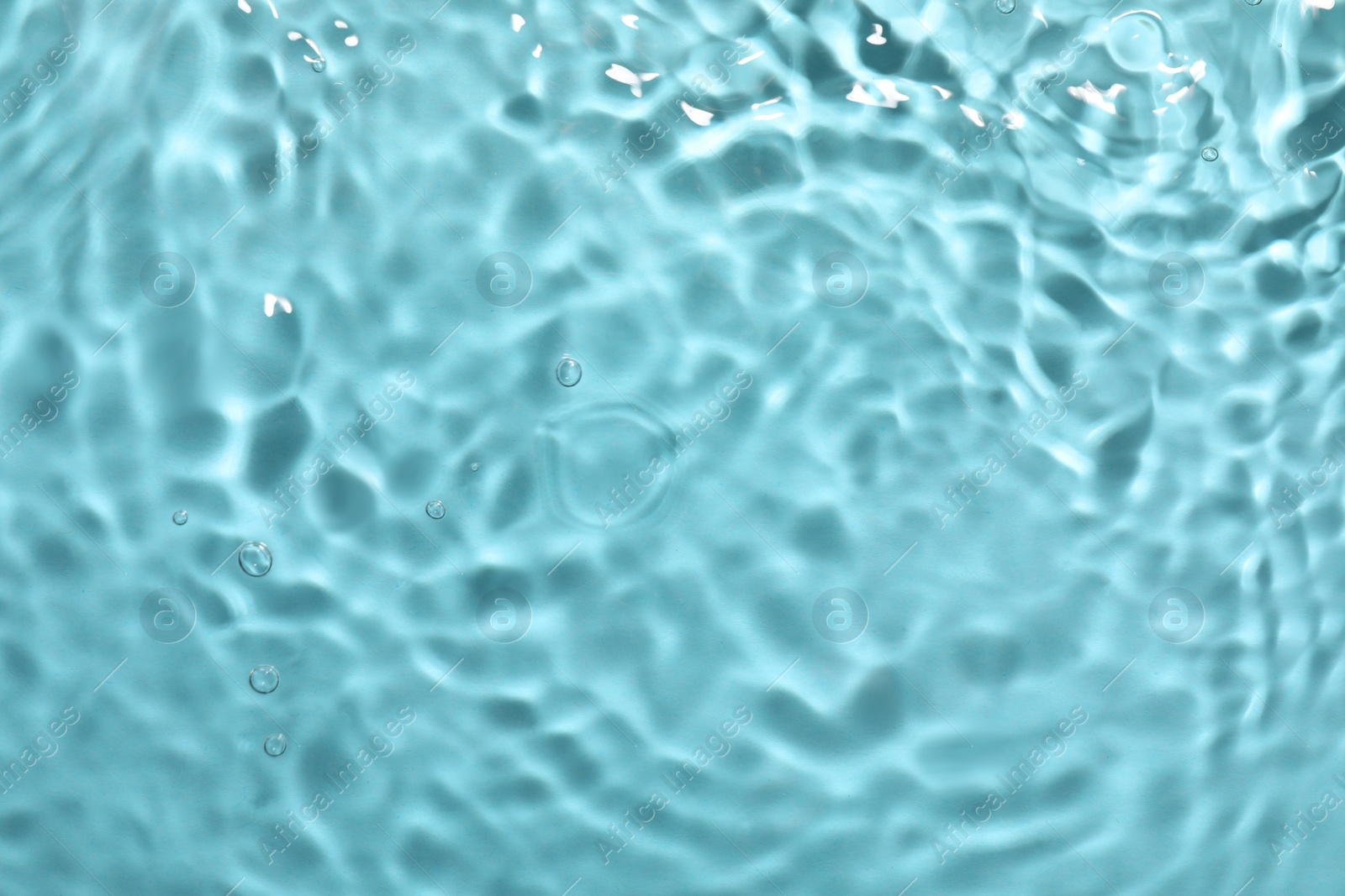 Photo of Closeup view of water with rippled surface on light blue background