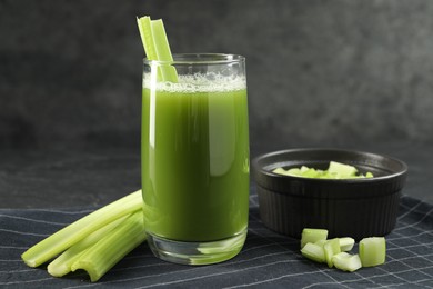 Glass of delicious celery juice and vegetables on table, closeup