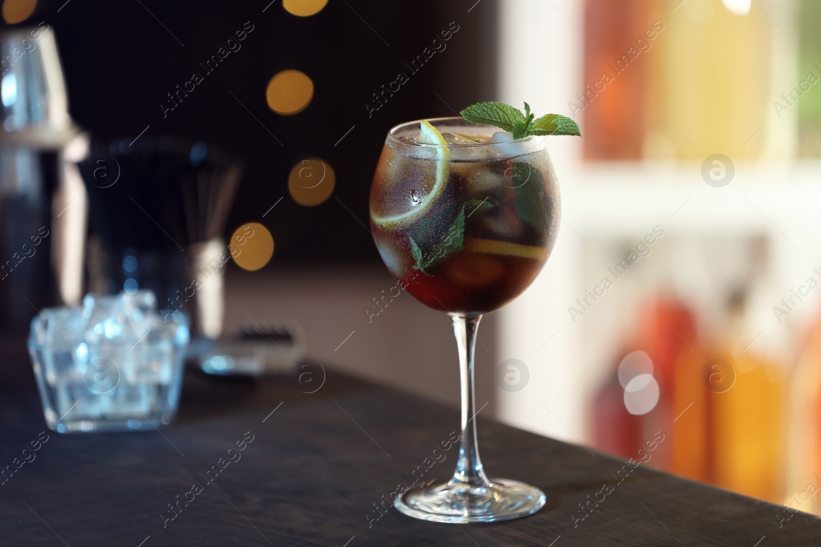 Photo of Fresh alcoholic cocktail with lemon and mint on bar counter