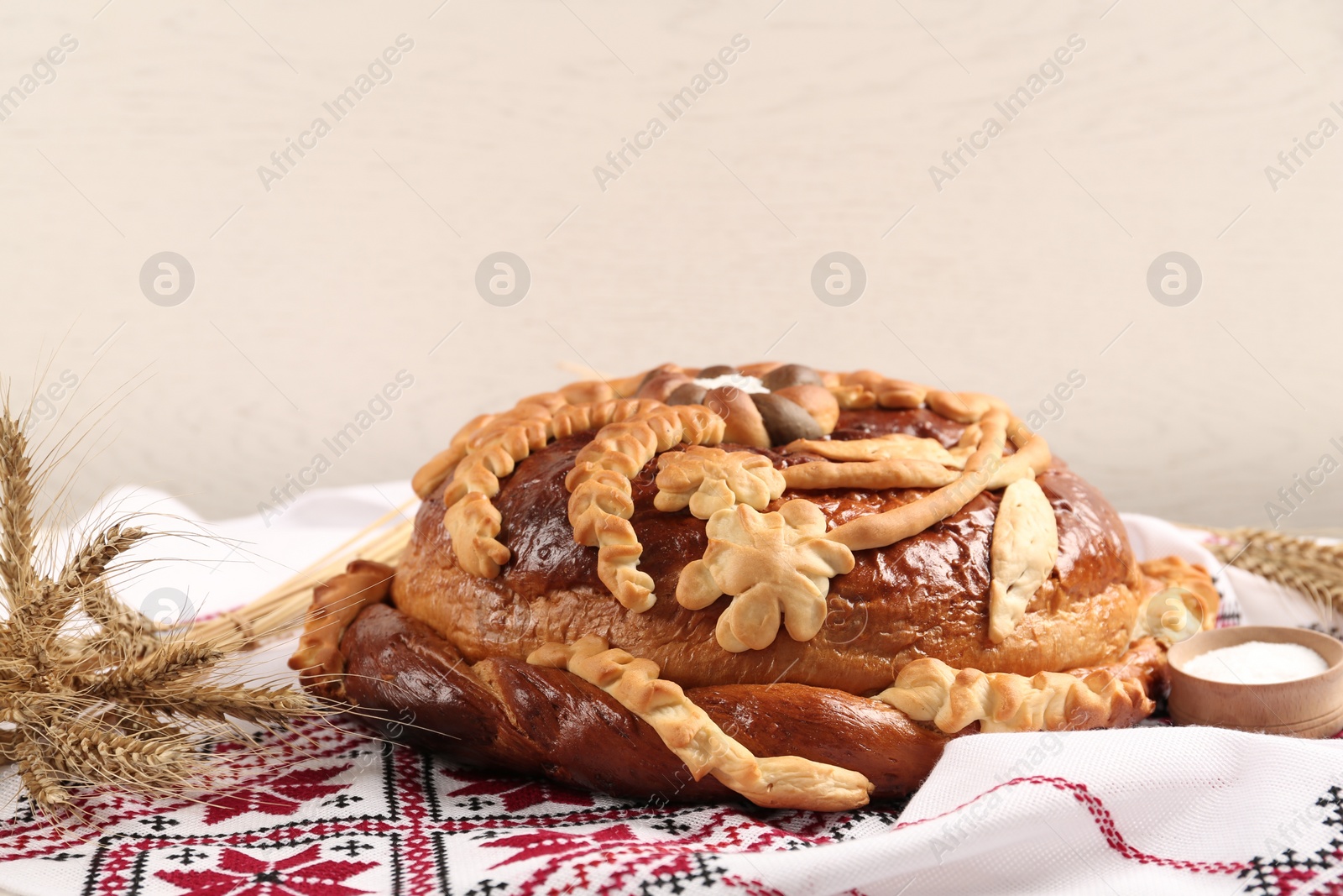 Photo of Rushnyk with korovai on light background. Ukrainian bread and salt welcoming tradition