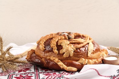 Rushnyk with korovai on light background. Ukrainian bread and salt welcoming tradition