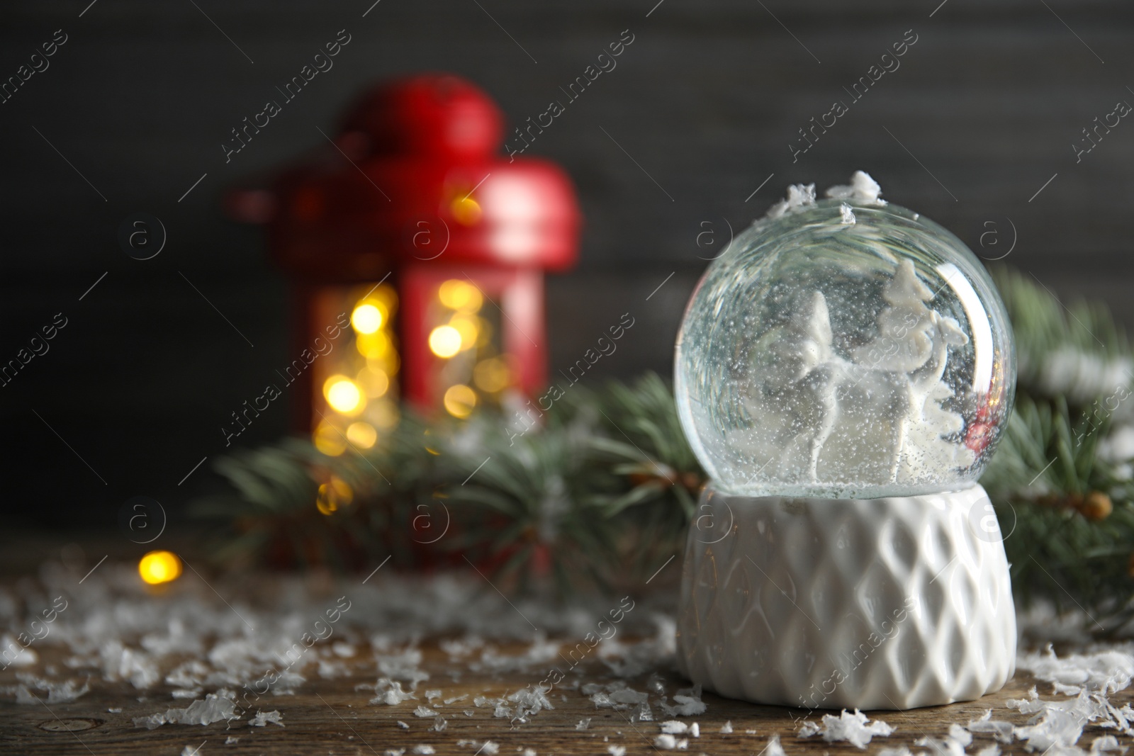 Photo of Magical snow globe with deer and trees on wooden table. Space for text