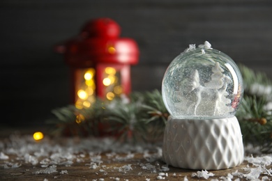 Magical snow globe with deer and trees on wooden table. Space for text