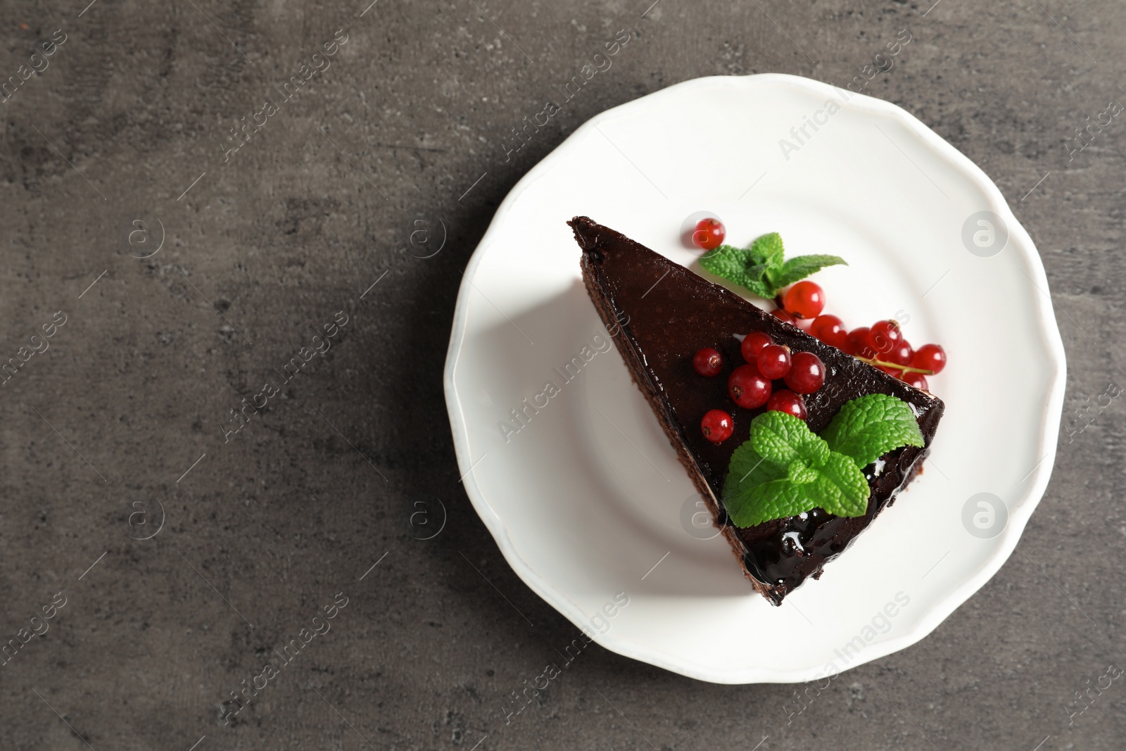 Photo of Plate with slice of tasty homemade chocolate cake and space for text on table, top view