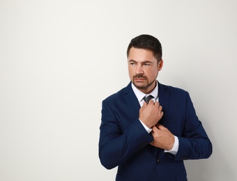 Portrait of handsome man in suit on light background. Space for text