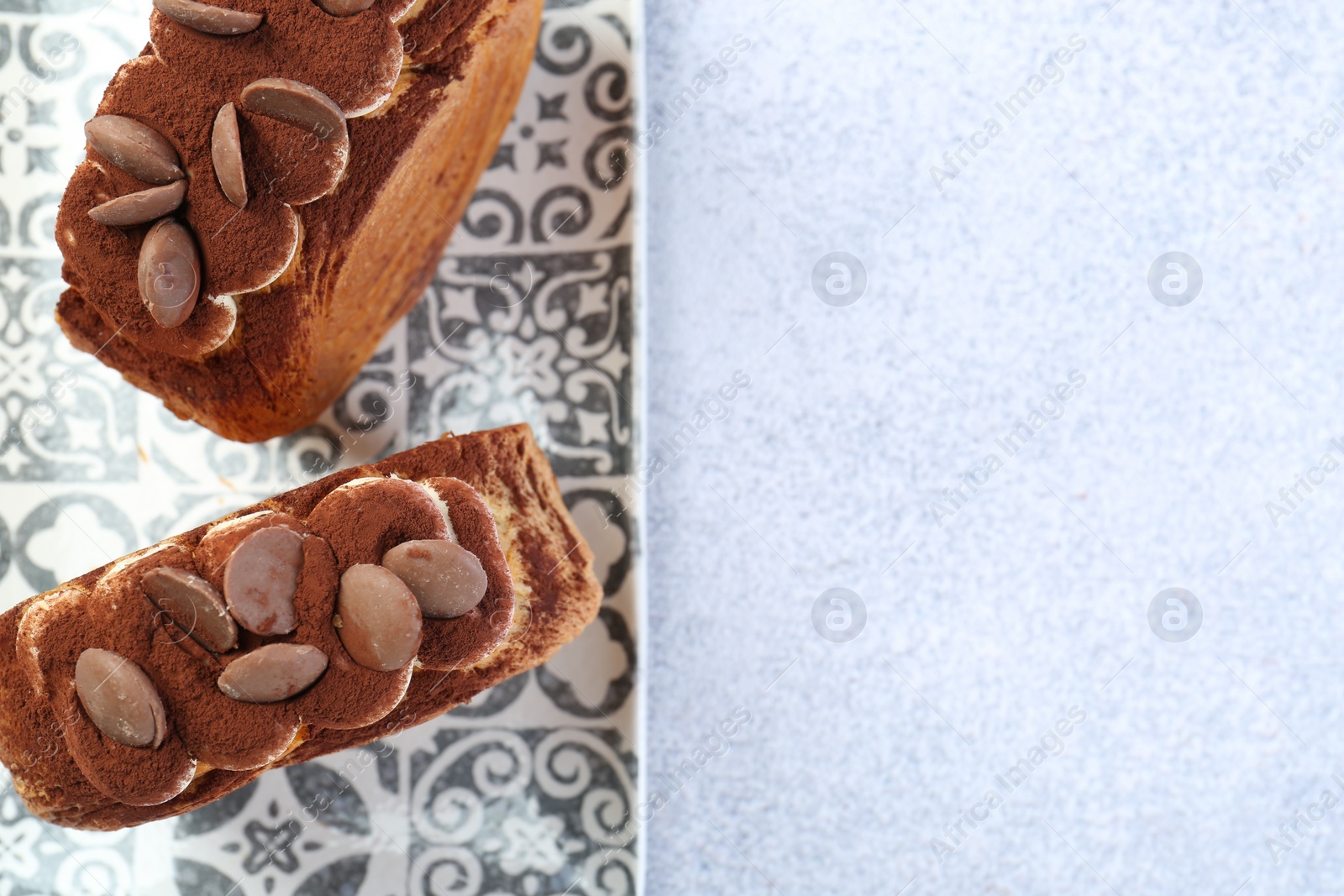 Photo of Tasty puff pastry. Supreme croissants with chocolate chips and cream on grey table, top view. Space for text