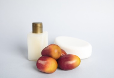 Fresh ripe palm oil fruits and cosmetic products on white background
