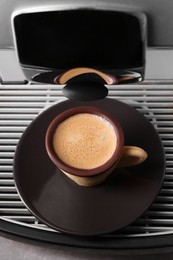 Photo of Coffee machine with delicious edible biscuit cup, above view