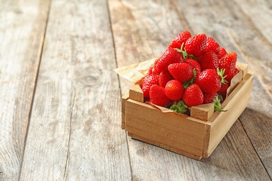 Photo of Crate with ripe strawberries on wooden background