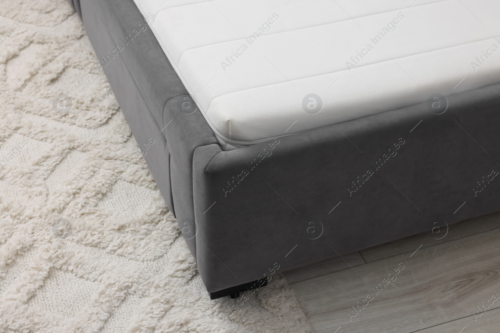 Photo of Comfortable bed with new soft mattress indoors