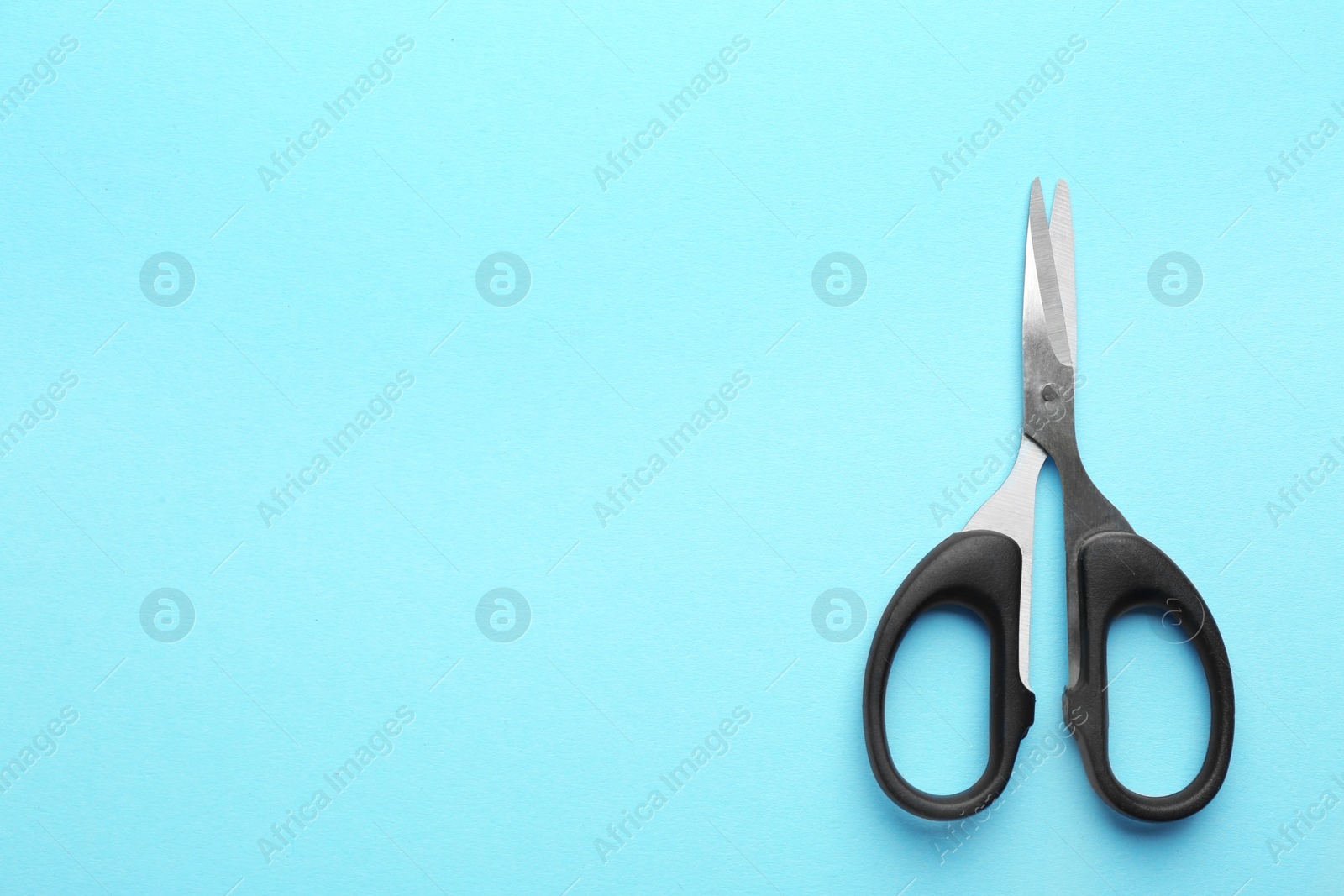 Photo of Pair of sharp scissors on color background, top view. Space for text