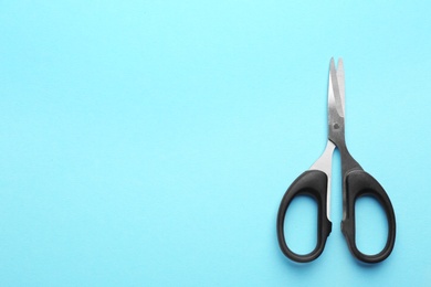 Photo of Pair of sharp scissors on color background, top view. Space for text