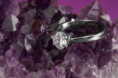 Photo of Beautiful luxury engagement ring with gemstone on amethyst, closeup