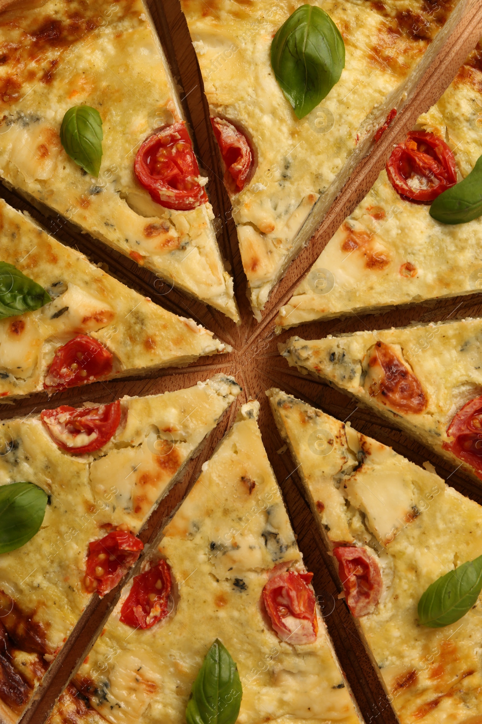 Photo of Delicious homemade cheese quiche on board, top view