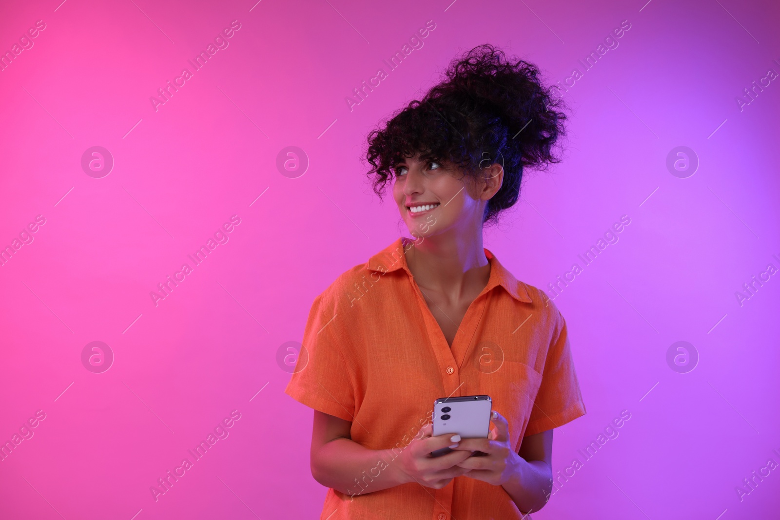 Photo of Woman sending message via smartphone on color background, space for text