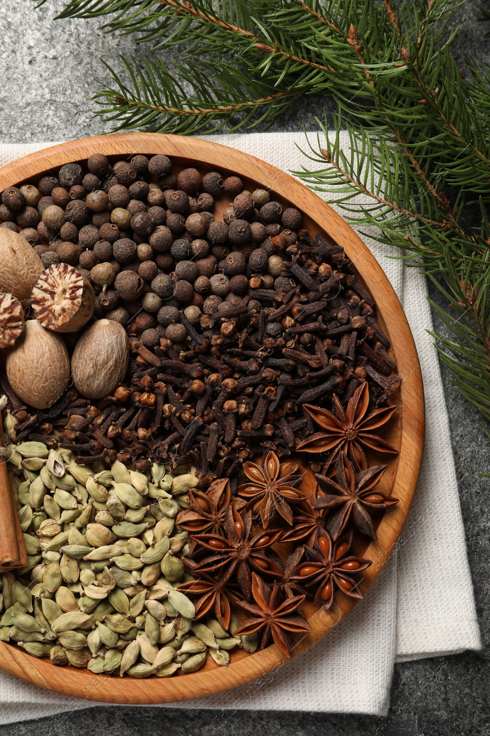 Photo of Different spices, nuts and fir branches on table, flat lay