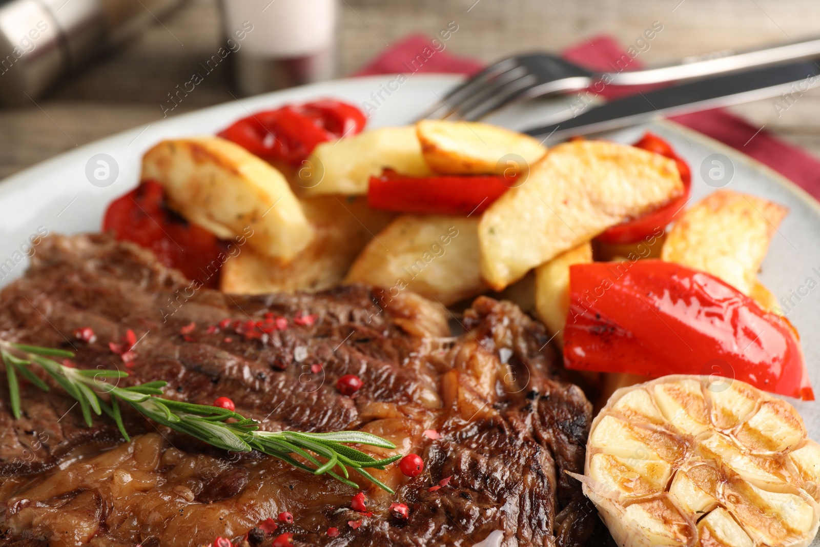 Photo of Delicious grilled beef steak and vegetables on plate, closeup