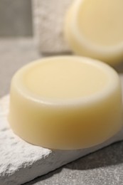 Photo of Solid shampoo bar on grey background, closeup. Hair care