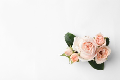 Beautiful roses and space for text on white background, top view