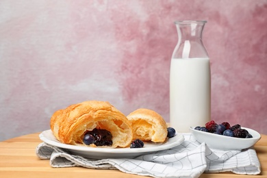 Photo of Tasty croissant with jam served for breakfast on table