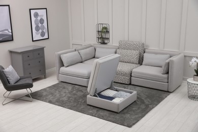 Photo of Open section with storage near modular sofa in living room. Interior design