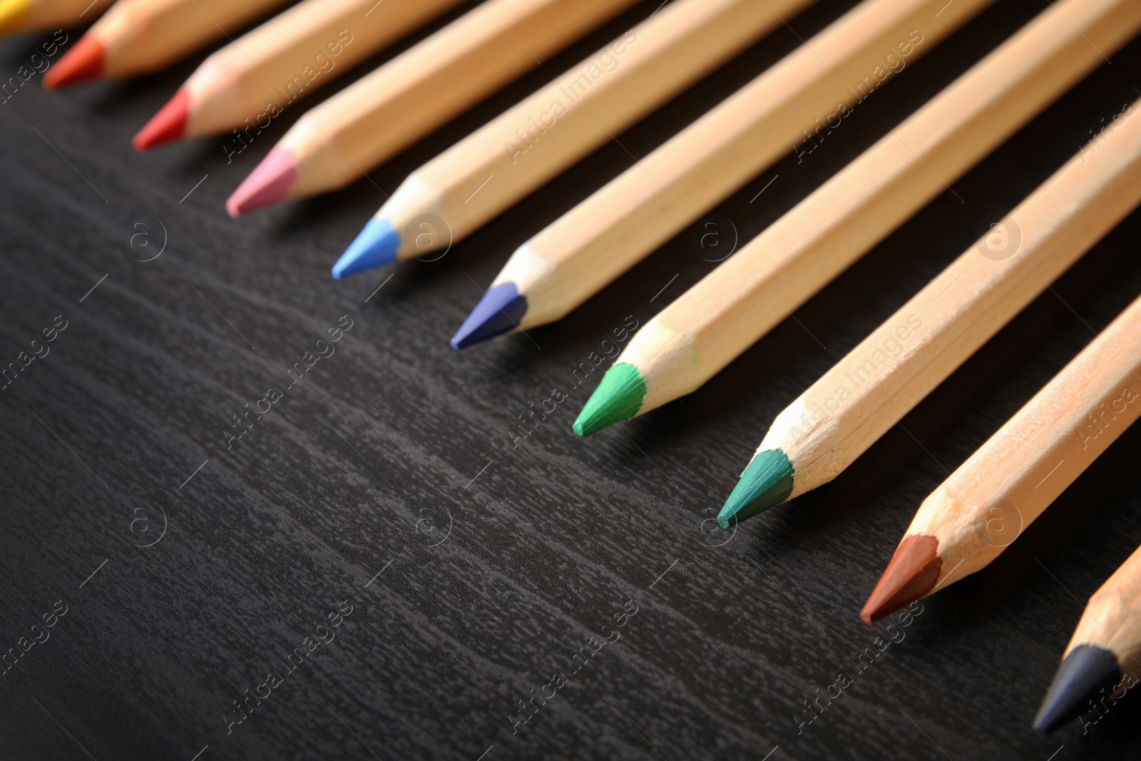 Photo of Pencils of different colors on wooden background. School stationery