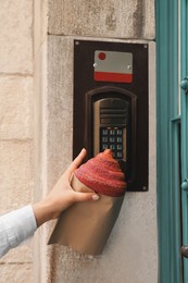 Photo of Woman with delicious croissant and ringing doorbell outdoors, closeup