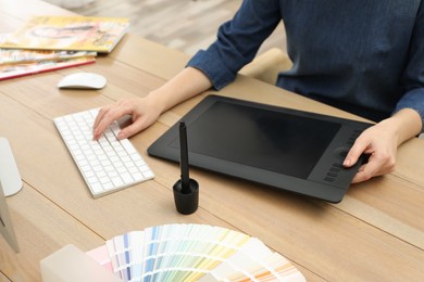 Photo of Professional designer working on graphic tablet at desk, closeup