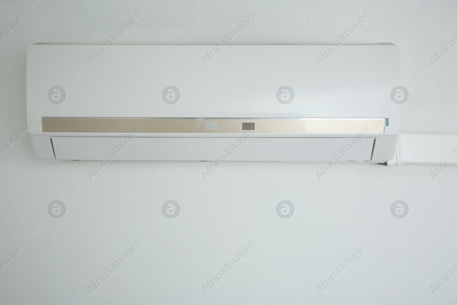 Photo of Modern air conditioner on white wall indoors