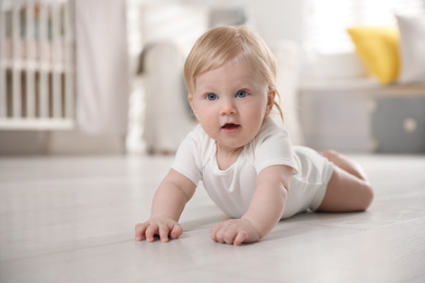 Photo of Cute little baby on floor at home