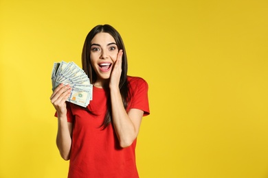 Young woman with money on color background. Space for text