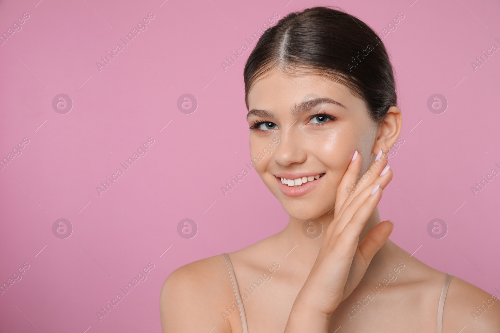 Photo of Portrait of pretty girl on pink background, space for text. Beautiful face with perfect smooth skin