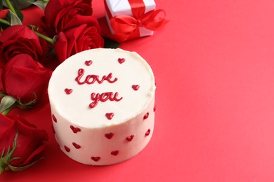 Photo of Bento cake with text Love You, roses and gift box on red table, space for text. St. Valentine's day surprise