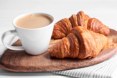 Photo of Tasty breakfast. Cup of coffee and croissants on table, closeup