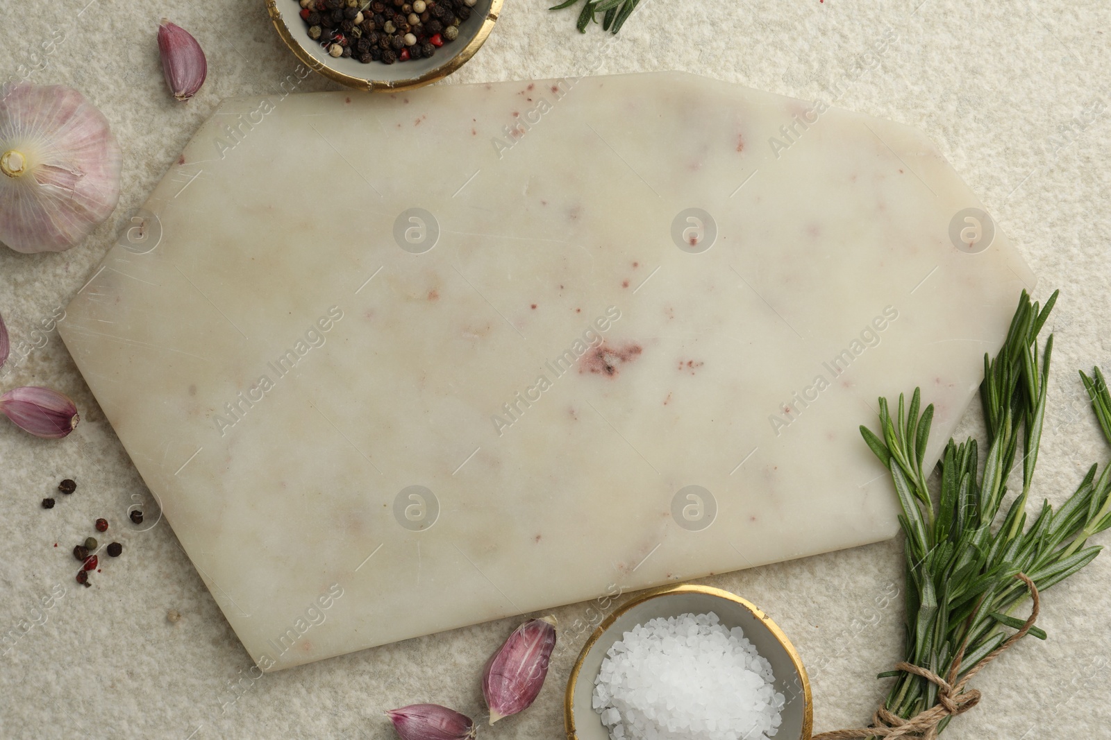 Photo of Cutting board, salt, pepper, rosemary and garlic on white textured table, flat lay. Space for text