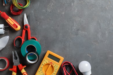 Photo of Flat lay composition with electrician's tools and accessories on grey background, space for text