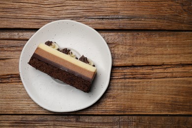 Plate with tasty chocolate mousse cake on wooden table, top view. Space for text