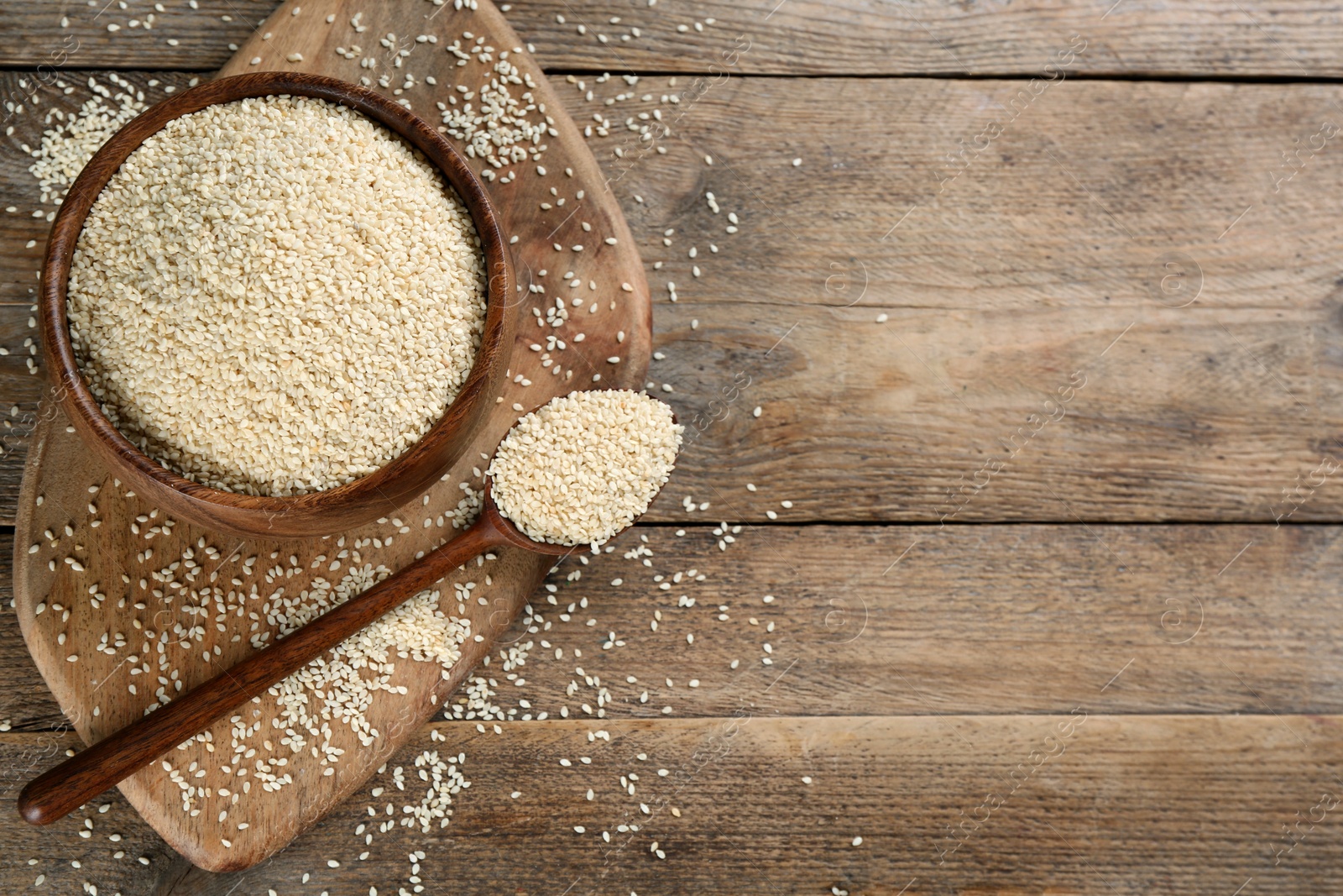 Photo of Sesame seeds on wooden table, flat lay. Space for text