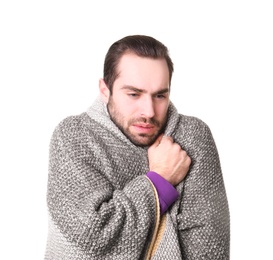 Young man with cold wrapped in blanket on white background