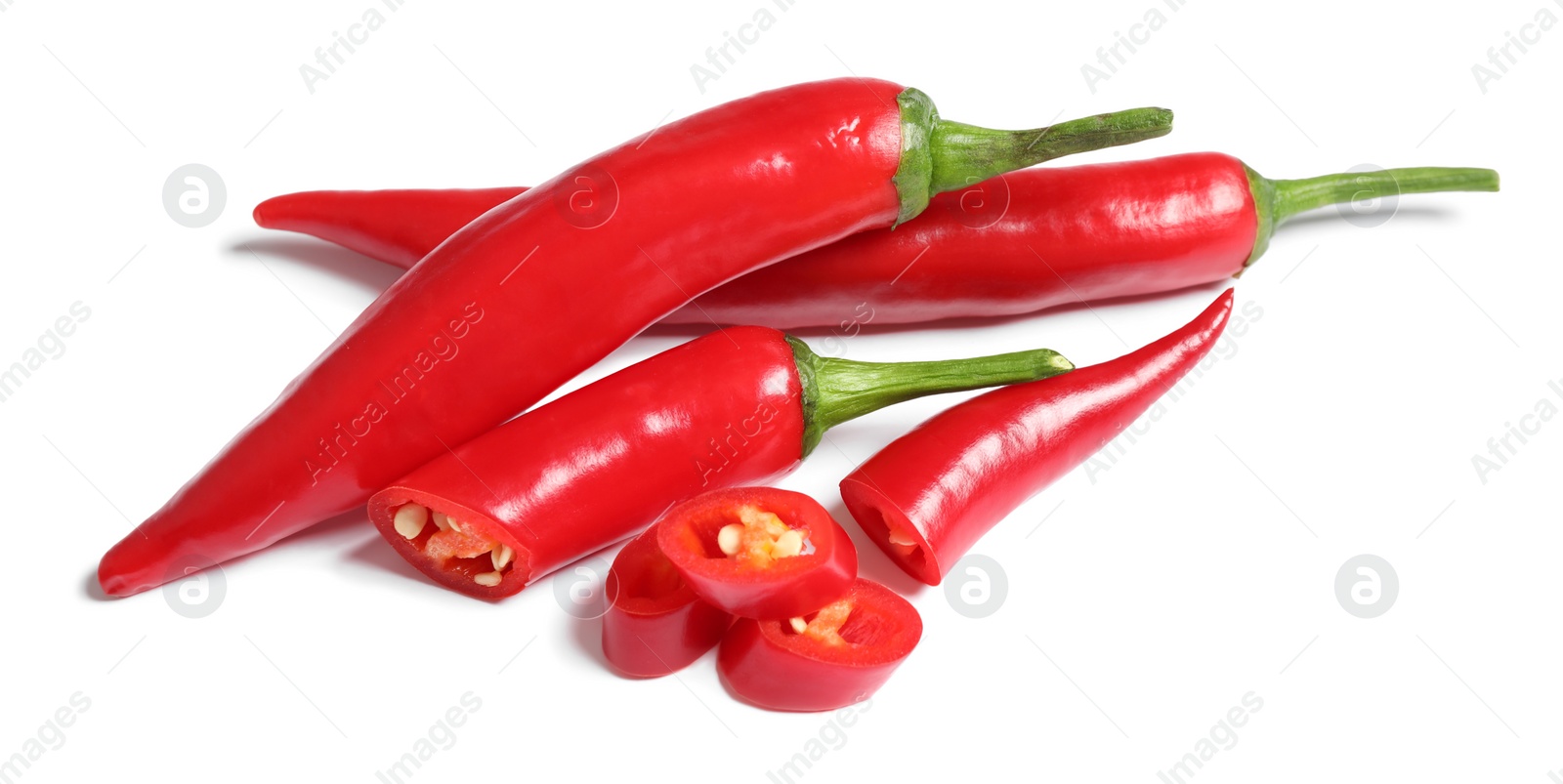 Photo of Cut and whole red hot chili peppers on white background