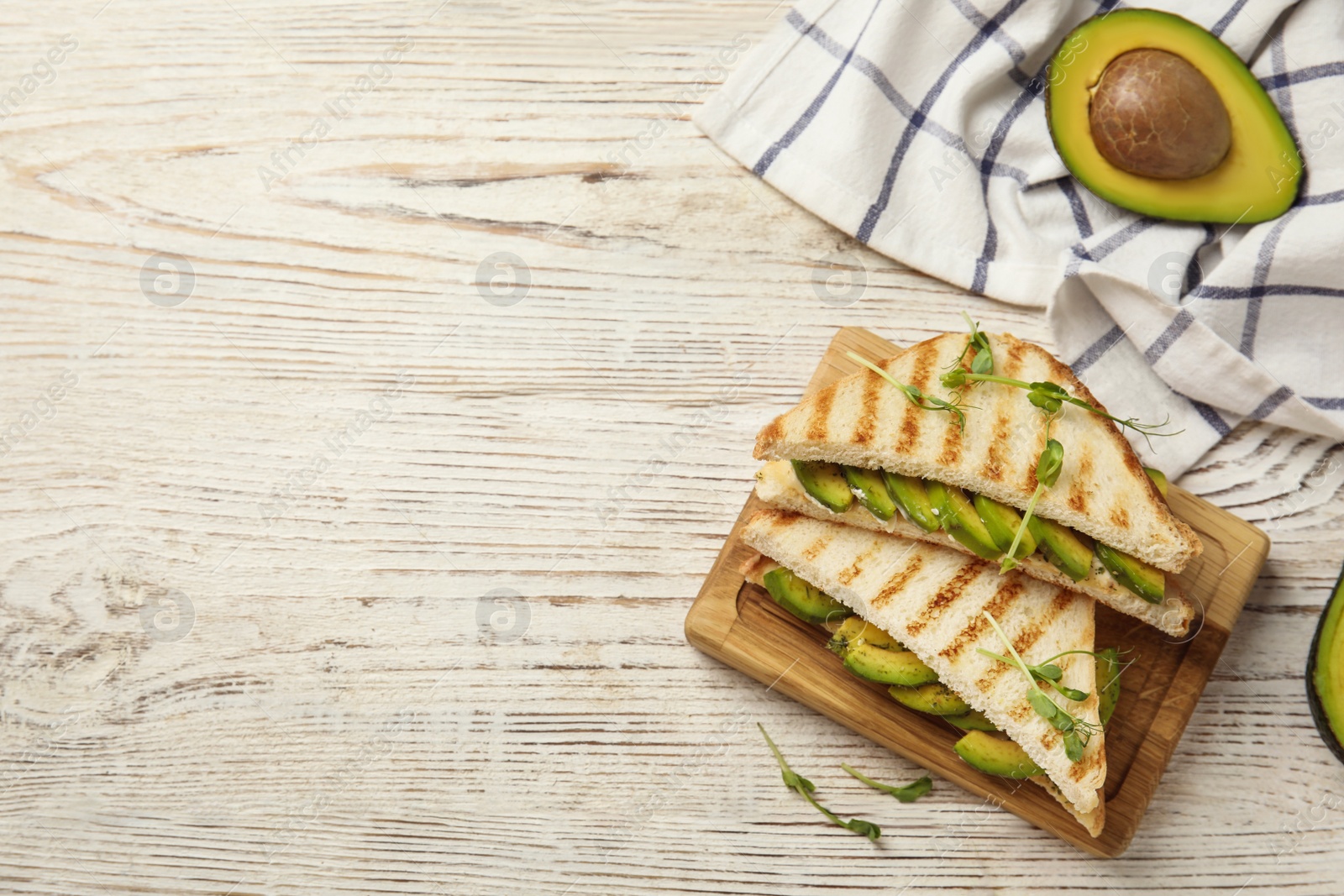 Photo of Flat lay composition with avocado sandwiches on white wooden table. Space for text