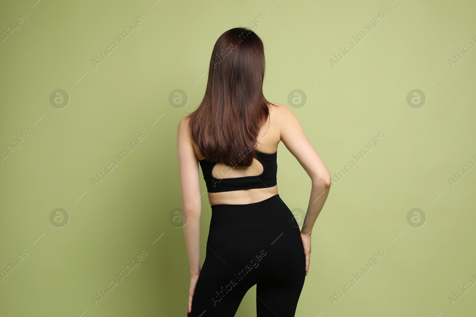 Photo of Woman with slim body on green background, back view