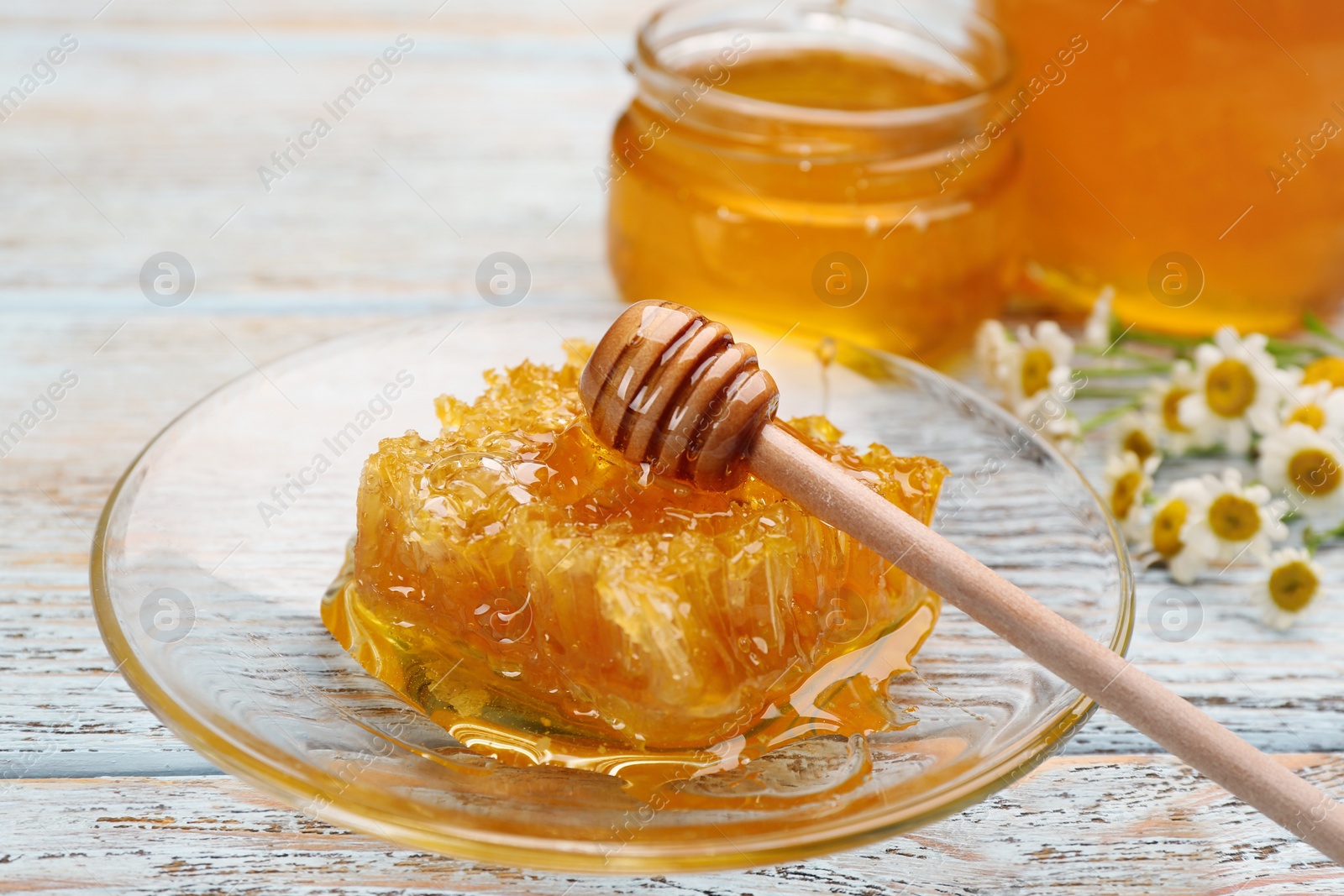 Photo of Tasty honey combs on light blue wooden table, closeup