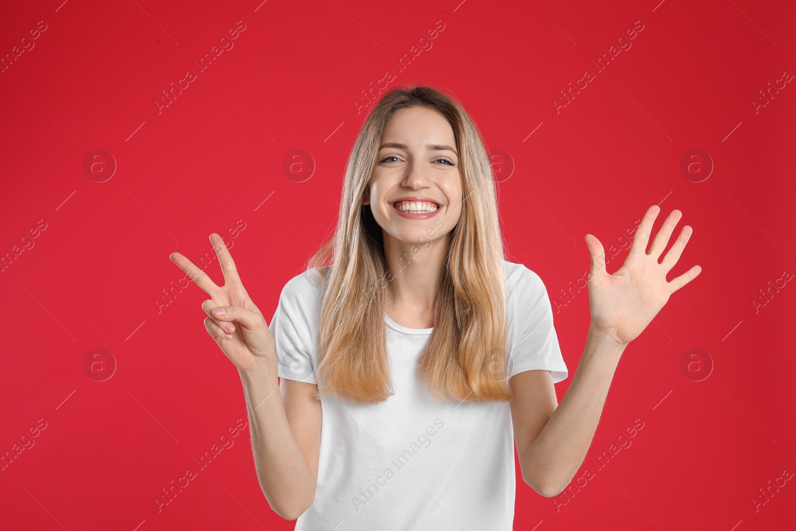 Photo of Woman showing number seven with her hands on red background