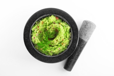 Mortar and pestle with delicious guacamole isolated on white, top view