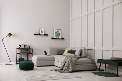 Photo of Living room with comfortable grey sofa and stylish interior elements