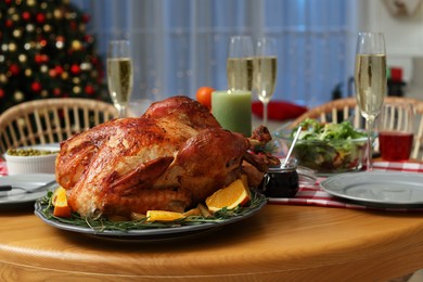 Photo of Festive dinner with delicious baked turkey and sparkling wine on table indoors. Christmas celebration