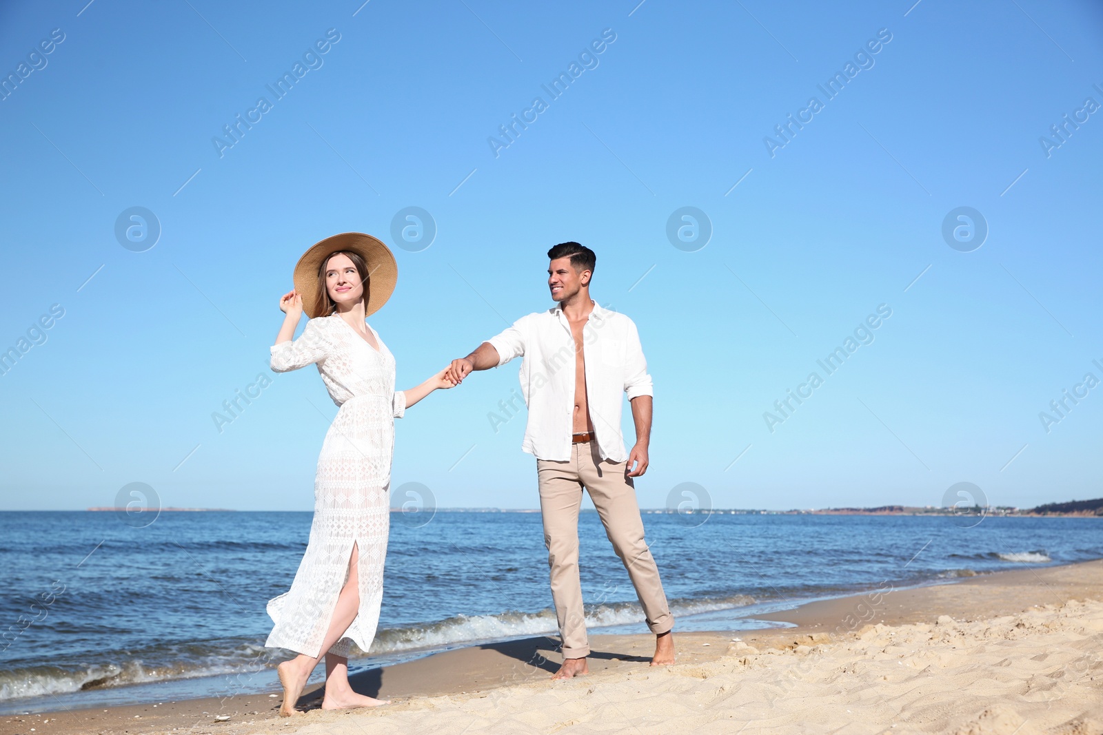 Photo of Lovely couple walking together on sandy beach