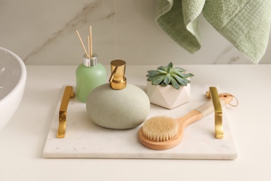 Photo of Air reed freshener, toiletries and plant on countertop in bathroom